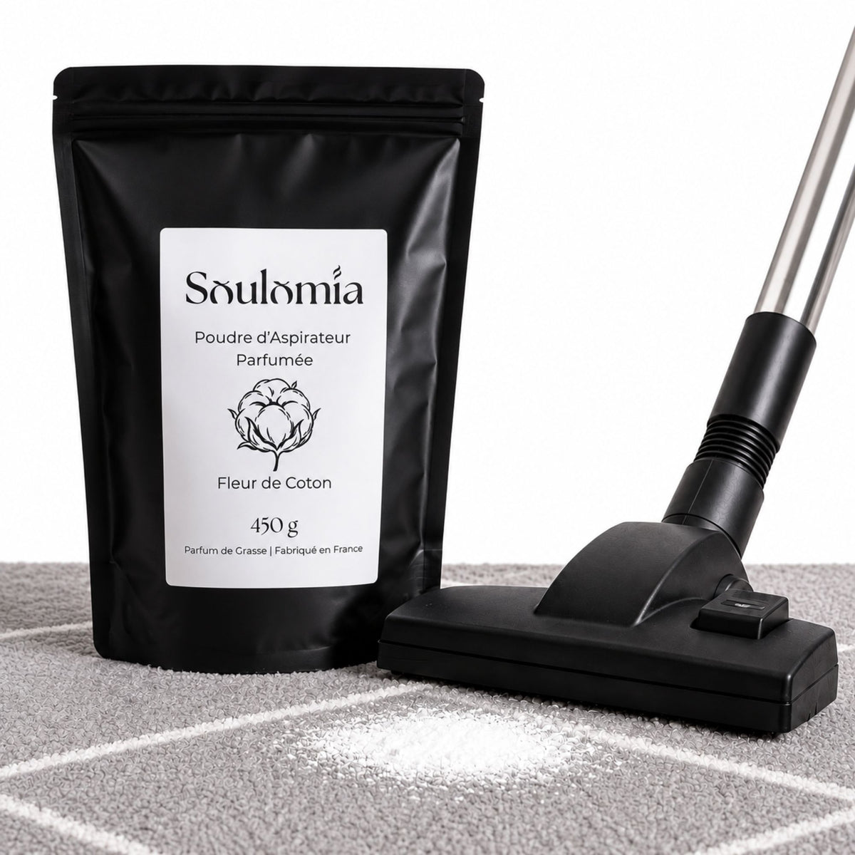 Poudre d’aspirateur parfumée Soulomia Fleur de Coton et aspirateur sur un tapis